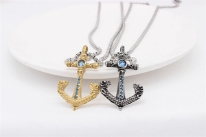 Macro detail of retro anchor pendant featuring a large blue stone and skull relief