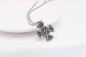 Close-up of vintage Viking Celtic knot cross pendant in stainless steel with box chain