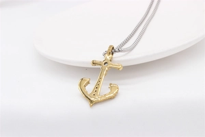 Macro shot of gold anchor pendant back with hollow structure and silver box chain