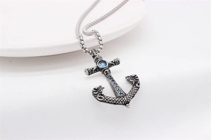 Macro detail of retro anchor pendant with blue stones and skull engraving details