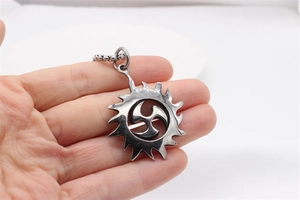 Macro view of retro sun pendant with Tomoe symbol and beaded chain for men