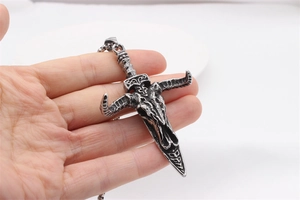 Close-up of retro punk bull head dagger pendant in blackened stainless steel finish