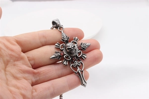 Détail du pendentif croix gothique rétro avec crâne et pierres de zircone rouge vif