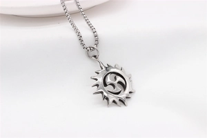 Macro shot of silver vintage sun pendant necklace featuring Tomoe symbol on box chain