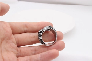 Close-up of vintage steel ring featuring intricate dragon scale texture and relief details