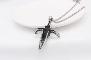 Macro shot of retro gothic sword pendant with antique silver finish on a round tray