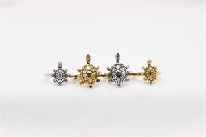 Detail view of retro turtle rings in gold and silver finishes across two sizes