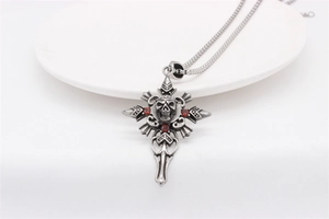 Détail du pendentif croix crâne gothique avec pierres de zircon rouge sur chaîne carrée