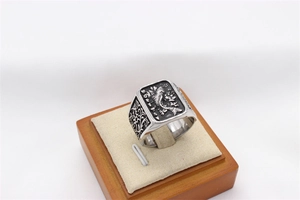 Macro view of men's vintage steel ring with koi carp relief and floral engravings