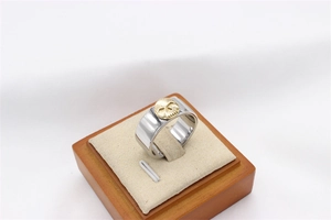 Close-up of punk style ring with golden skull relief on silver stainless steel band