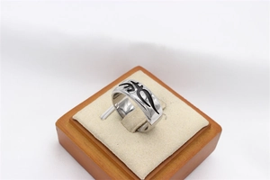 Macro shot of vintage silver steel ring with gothic totem carving in a wooden display box