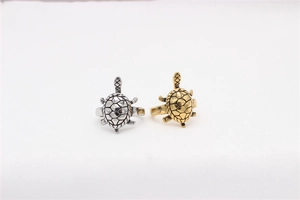 Detail of vintage turtle rings in gold and silver finish with textured shell engraving