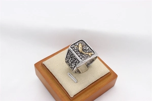 Detailed macro view of vintage stainless steel ring with golden koi carp relief and floral patterns