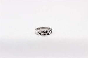 Macro view of vintage silver steel ring with detailed black rose floral engraving