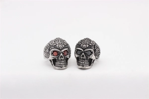 Detailed view of vintage gothic skull rings with intricate floral carving and red/black gems