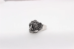 Macro shot of a vintage silver tribal mask ring with oxidized metal carving details