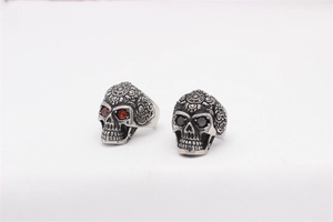 Detailed macro shot of vintage skull rings with mandala carvings and red and black gems