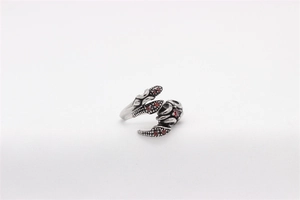 Macro detail of vintage scorpion ring with silver metal claws and red zircon stones
