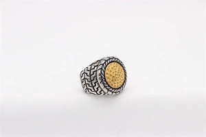 Macro shot of two-tone steel ring featuring hammered gold disc and woven band texture