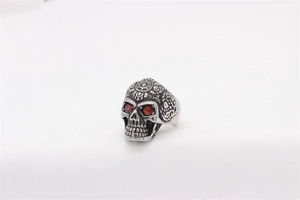 Macro shot of gothic skull ring with red gemstone eyes and mandala engravings