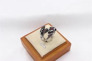 Macro detail of retro steel ring featuring scorpion claws and red gemstone inlays
