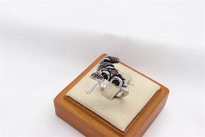 Detailed view of vintage scorpion ring with gothic silver relief and red zircons