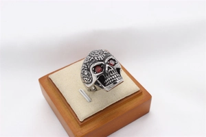 Detailed macro view of vintage skull ring featuring red zircon eyes and mandala carving