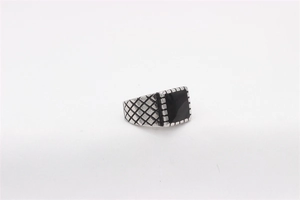 Macro detail of men's titanium ring with black onyx inlay and textured diamond pattern