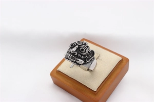 Macro detail of vintage tribal face mask ring with retro oxidized steel finish