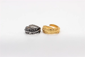 Detailed view of retro steel feather rings in vintage gold and silver adjustable finishes