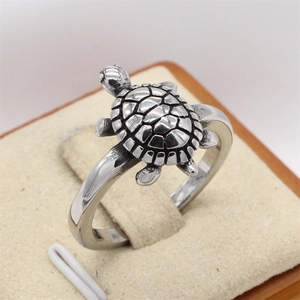 Retro turtle shaped stainless steel ring for men with detailed shell texture on beige velvet