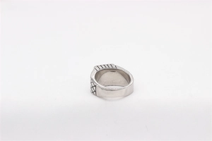Macro shot of vintage silver titanium ring with detailed grid texture and parallel stripes