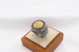 Detail of silver men's signet ring with golden hammered top and braided band texture