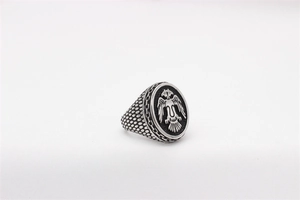 Close-up of vintage steel ring featuring a black double-headed eagle crest and dotted texture