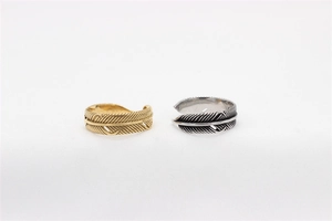 Close-up of retro feather rings in gold and silver finish with detailed textures