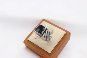 Detailed macro view of the black drip oil rectangle inlay and textured ring band