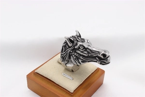 Detailed close-up of a vintage horse head ring with intricate metal hair and eye textures