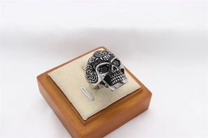 Detailed macro view of vintage skull ring with black stones and mandala relief