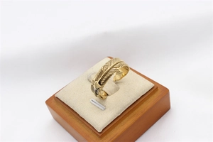 Detailed close-up of golden feather texture on retro titanium steel ring for men