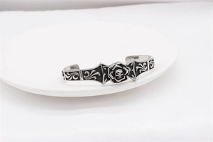 Detail view of retro silver skull rose gothic cuff bracelet with floral engraving