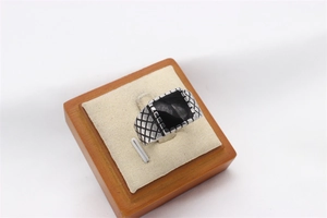 Close-up of retro men's stainless steel ring with black rectangular stone and grid texture