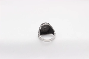 Macro view of vintage eagle signet ring showing matte silver texture and textured band details