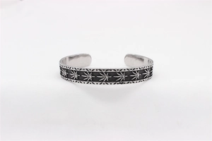 Close-up of retro stainless steel leaf pattern cuff bracelet with oxidized silver finish