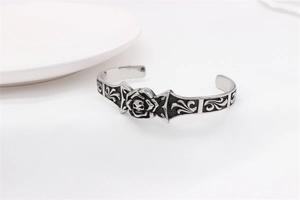 Detail of vintage gothic skull and rose carvings on a retro titanium steel cuff bracelet