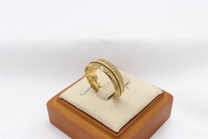Detailed close-up of golden vintage feather ring showing intricate texture on a jewelry stand