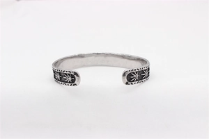Detail view of retro stainless steel cuff bracelet with vintage maple leaf engraving