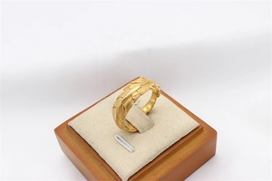 Macro detail of vintage gold feather texture on stainless steel ring for men