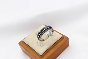 Detailed view of vintage steel feather ring showcasing oxidized textures and intricate carvings