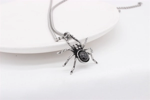 Macro shot of gothic spider pendant necklace with black gemstone and vintage steel finish