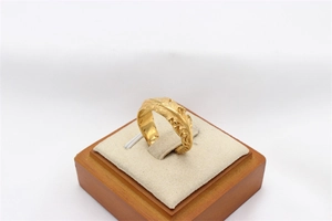 Detailed close-up of golden feather texture on vintage stainless steel ring
